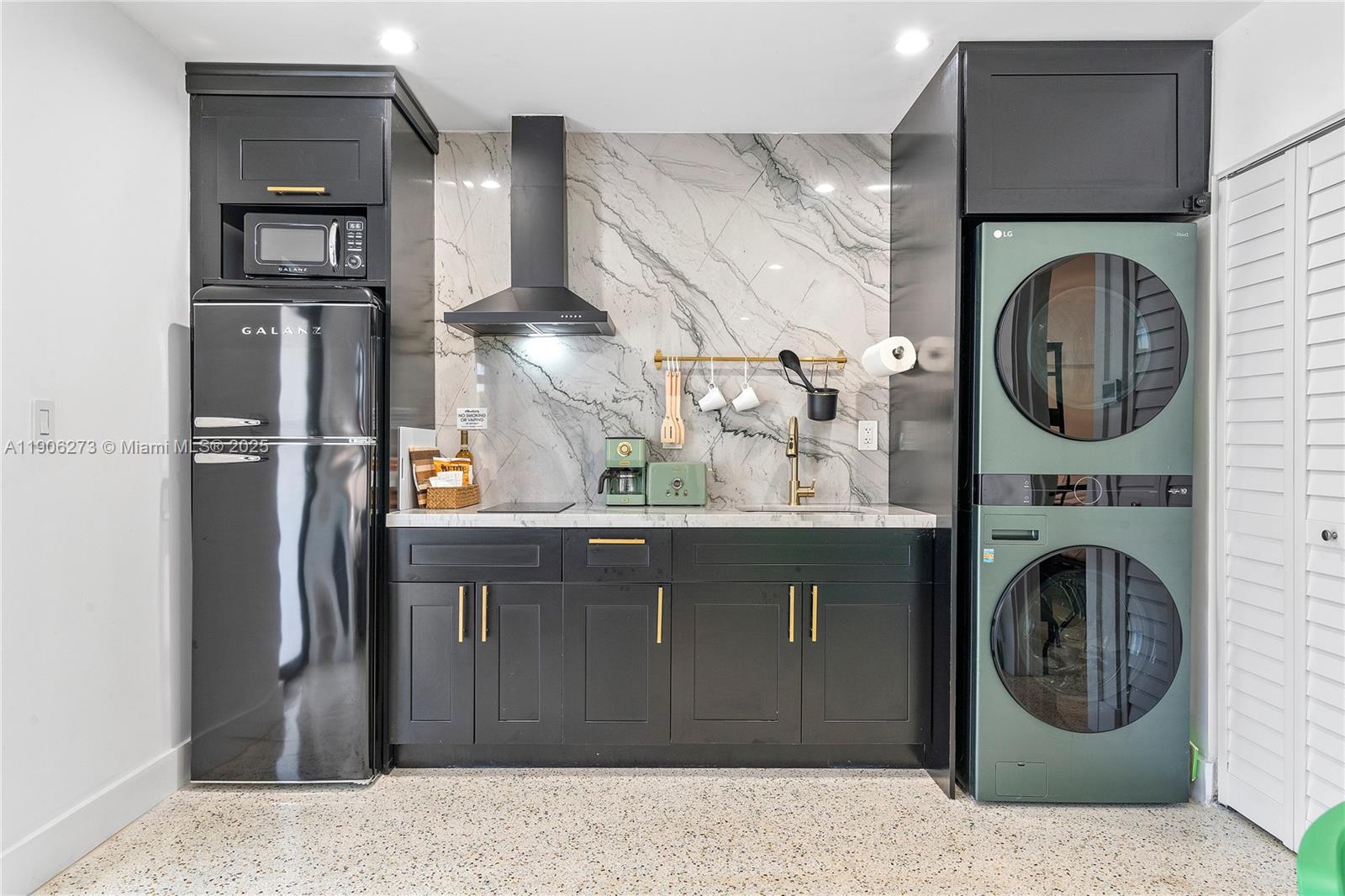 256 Northwest 57th Street Miami, FL 33127 - Photo 6 of 45 a kitchen with a refrigerator and cabinets