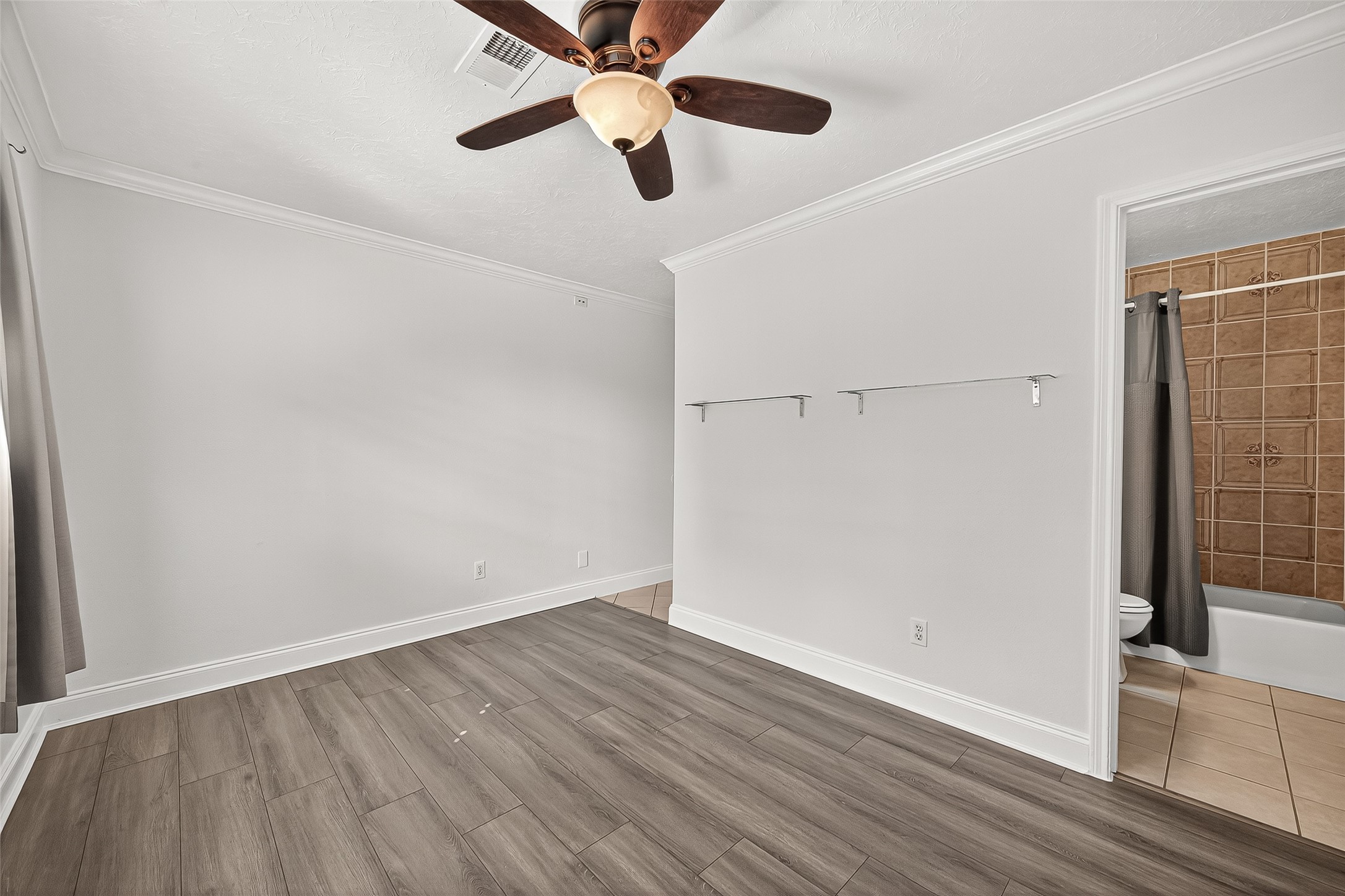 14007 Buffalo Speedway Houston, TX 77045 - Photo 28 of 46 an empty room with wooden floor a ceiling fan and windows