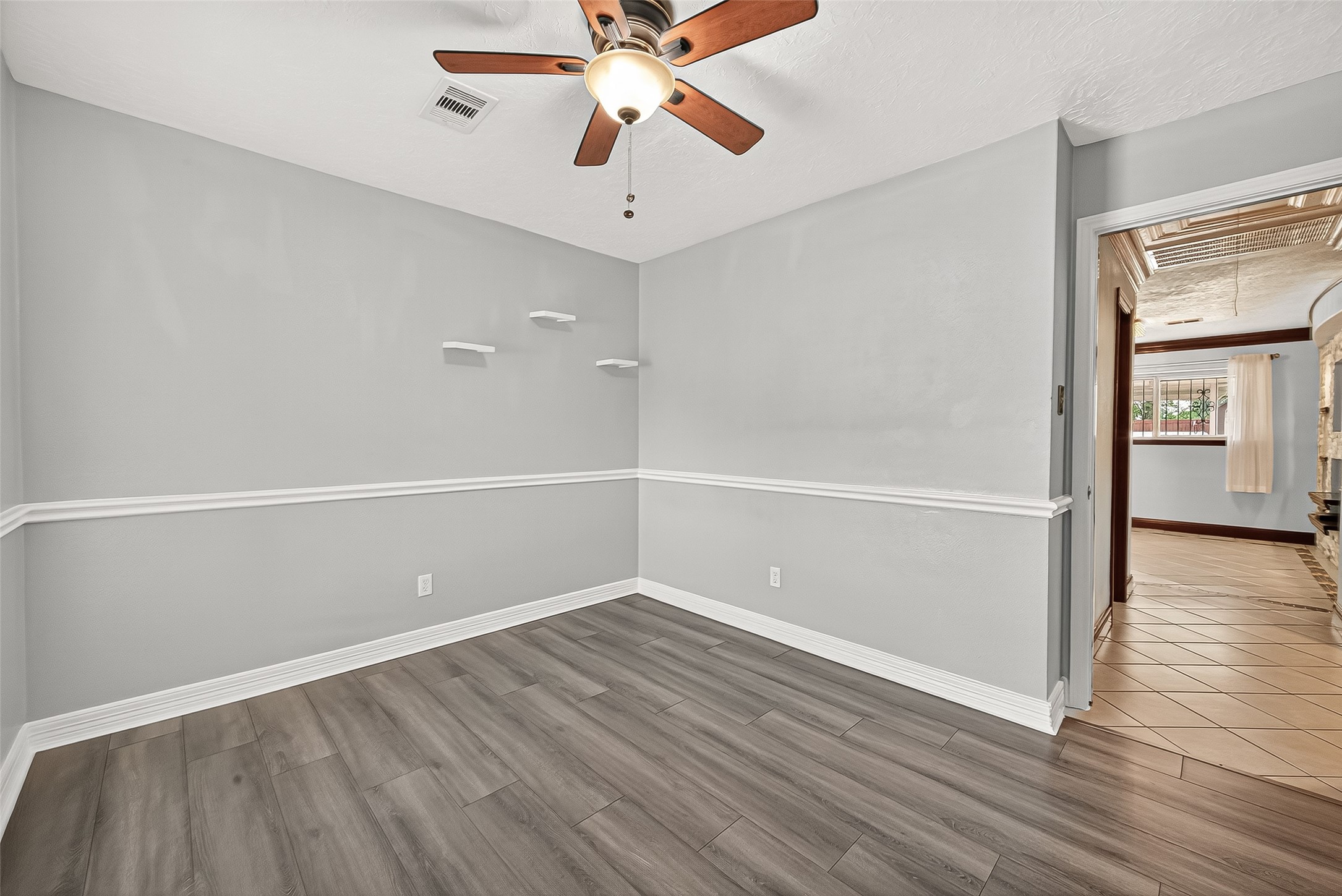 14007 Buffalo Speedway Houston, TX 77045 - Photo 31 of 46 an empty room with wooden floor chandelier fan and windows