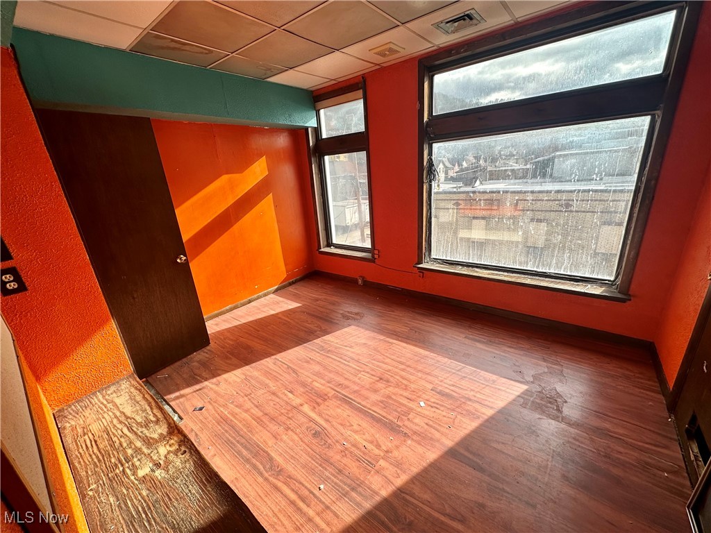 800 Main Street Follansbee, WV 26037 - Photo 11 of 20 Unfurnished room with dark hardwood / wood-style floors, a paneled ceiling, and plenty of natural light