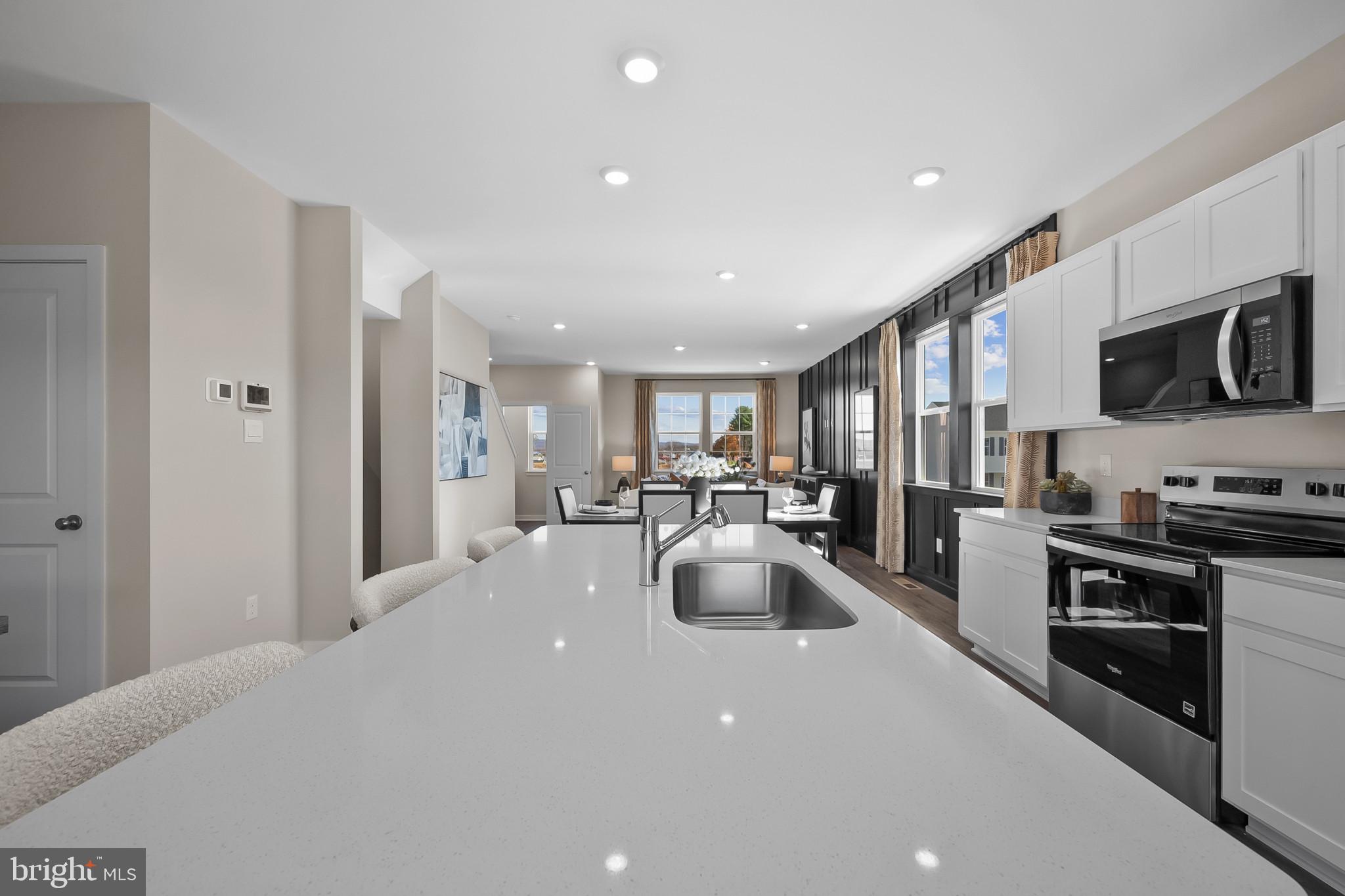 48 Aloma Street Ranson, WV 25438 - Photo 10 of 46 a kitchen with stainless steel appliances a stove a sink a refrigerator white cabinets and couches with wooden floor