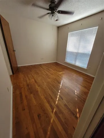 a view of a hallway with wooden floor and stairs