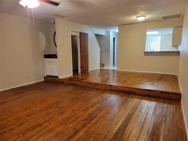 a view of a livingroom with wooden floor and a staircase
