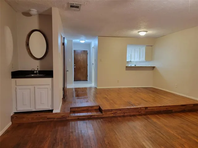 a view of a room with wooden floor and cabinet