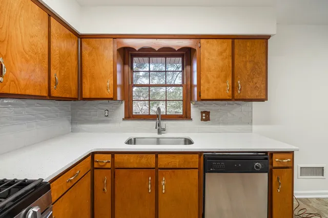a kitchen with stainless steel appliances granite countertop a sink a stove and a refrigerator