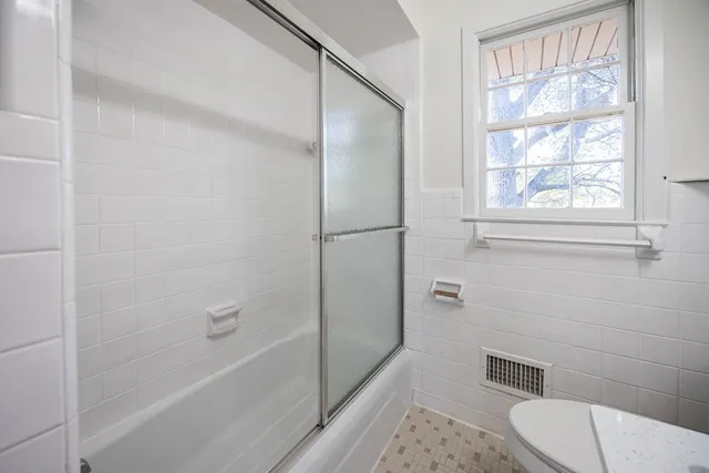 a bathroom with a toilet and a shower