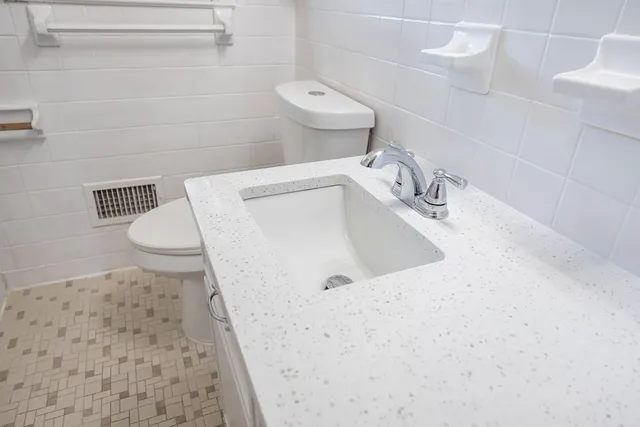 a bathroom with a sink a toilet and a mirror
