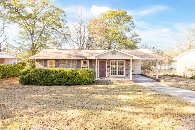 a front view of a house with a yard and potted plants