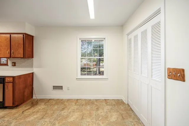 a view of an empty room with window and cabinet