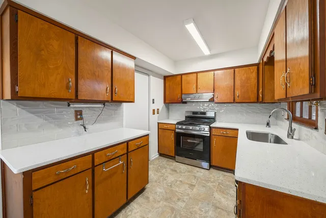 a kitchen with stainless steel appliances granite countertop a sink stove and refrigerator
