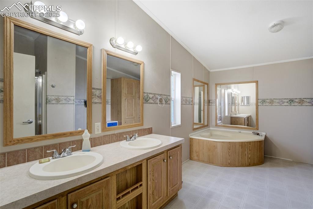 1435 Equestrian Point Yoder, CO 80864 - Photo 22 of 49 a spacious bathroom with a tub double sink and mirror