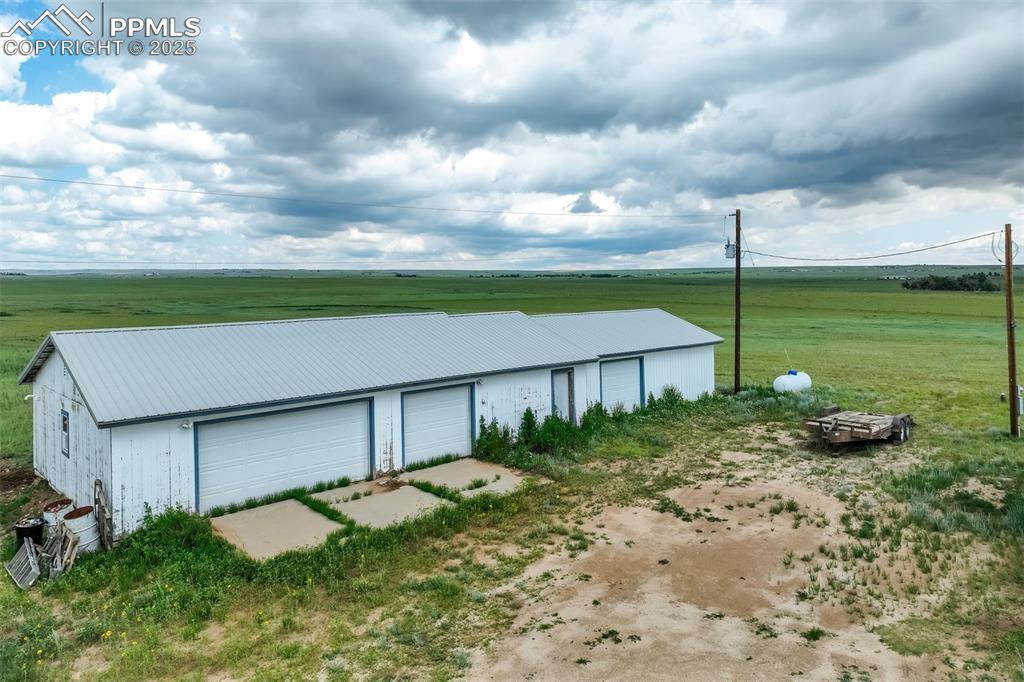 1435 Equestrian Point Yoder, CO 80864 - Photo 4 of 49 a backyard of a house with a yard and garage