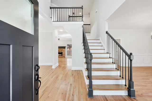 a view of a livingroom with wooden floor a fireplace and window
