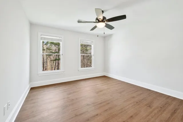 a view of a livingroom with wooden floor and ceiling fan