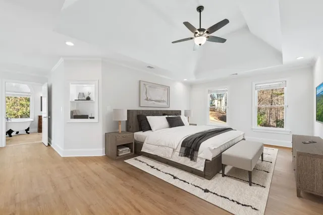 a spacious bathroom with a double vanity sink a mirror a bathtub and a window