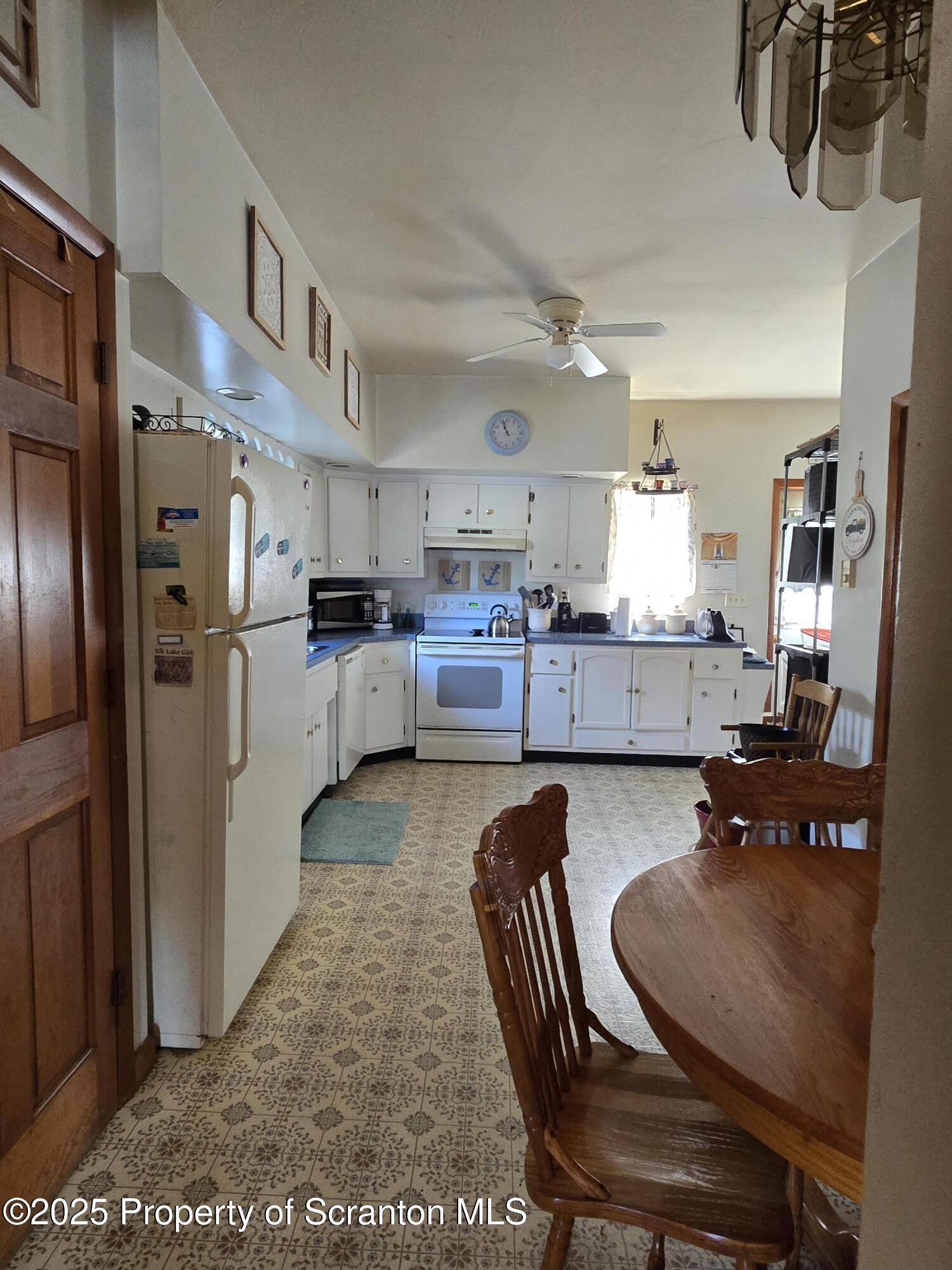 1228 Lake Road Factoryville, PA 18419 - Photo 22 of 31 a kitchen with refrigerator and chairs