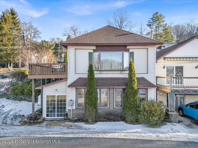 a aerial view of a house with a yard and lake view