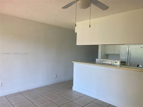 a kitchen with stainless steel appliances a sink a stove a refrigerator with white cabinets