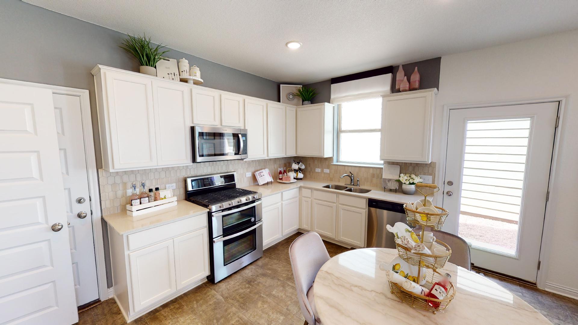 8105 Springsteen Drive Austin, TX 78744 - Photo 2 of 10 Kitchen featuring stainless steel appliances, white cabinetry, backsplash, and recessed lighting