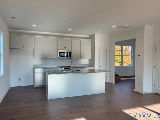 a kitchen with stainless steel appliances granite countertop a stove a sink and a refrigerator