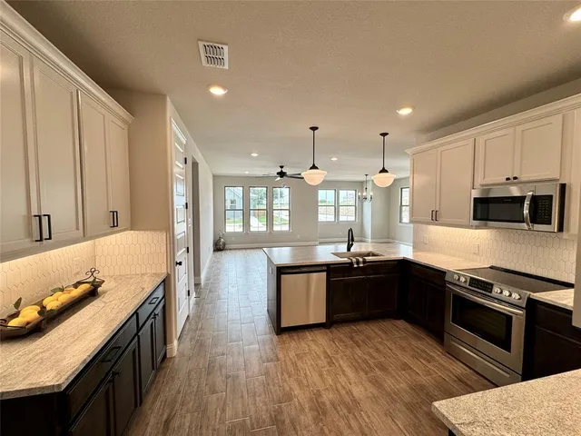 a large kitchen with stainless steel appliances granite countertop a stove and a sink