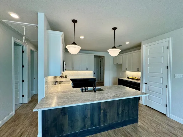 a kitchen with a refrigerator a sink and wooden floor