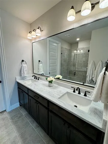 a bathroom with double vanity sinks and a mirror