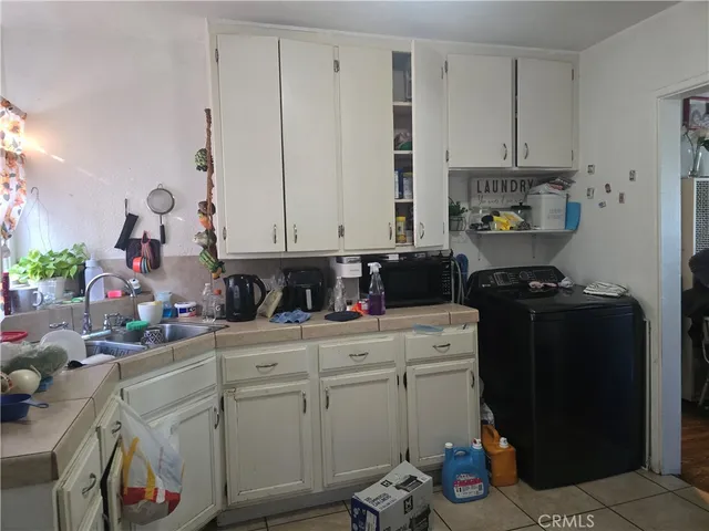 a kitchen with white cabinets and appliances