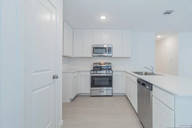 a kitchen with stainless steel appliances a stove sink and cabinets