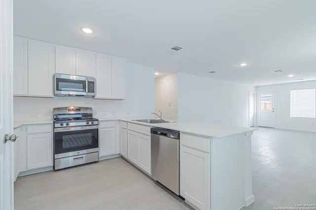a kitchen with stainless steel appliances granite countertop a stove and a sink
