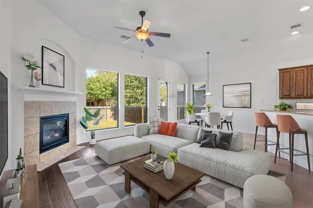 a living room with furniture fireplace and a large window