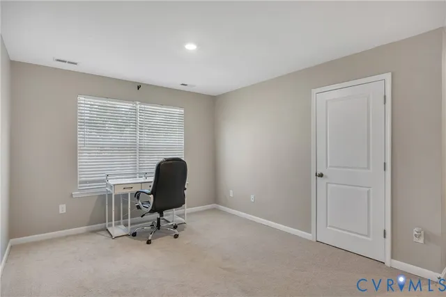 a view of a workspace with furniture and a window