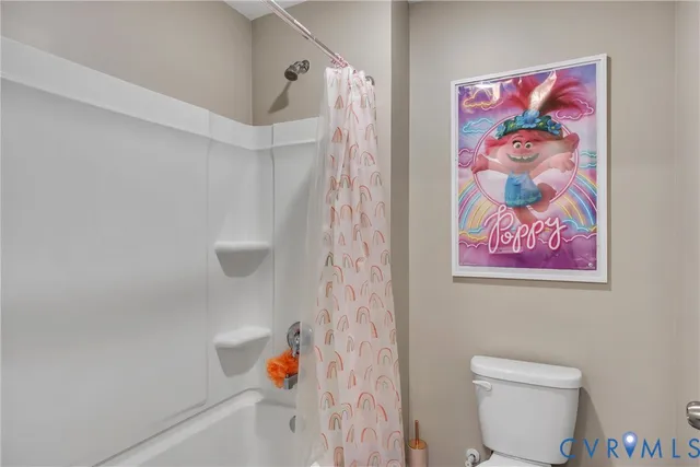 a bathroom with a toilet and a shower curtain