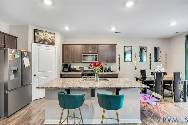 a kitchen with granite countertop a refrigerator and a dining table