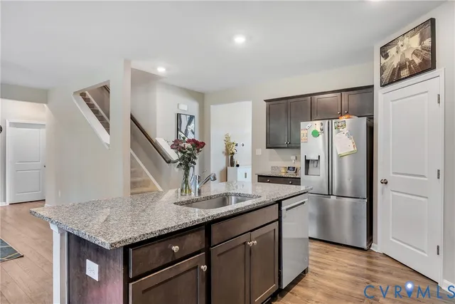 a kitchen with stainless steel appliances granite countertop a refrigerator a stove and a sink