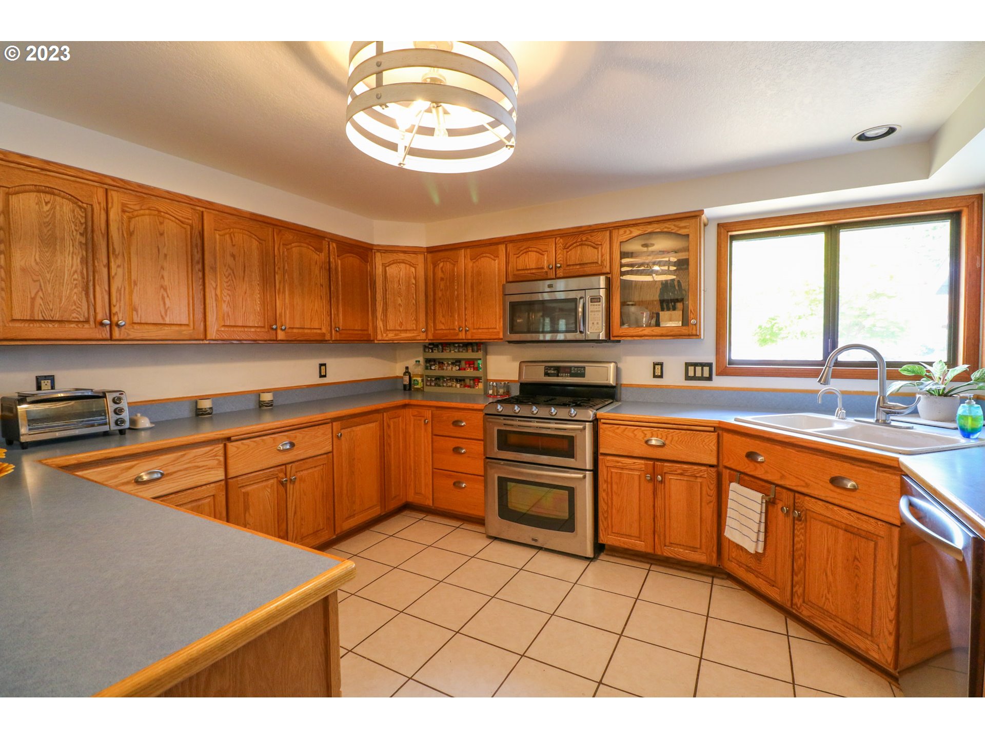 2075 Timberline Drive Coos Bay, OR 97420 - Photo 19 of 39 a kitchen with stainless steel appliances granite countertop a stove a sink and a microwave