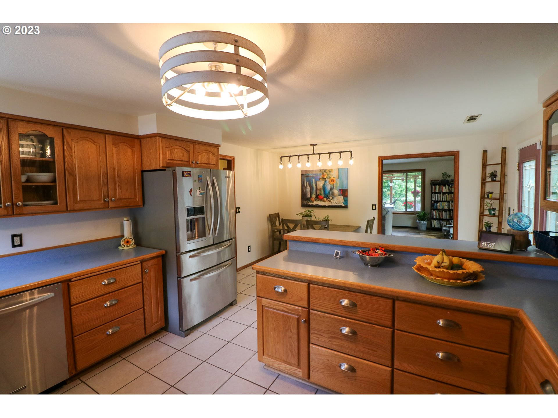 2075 Timberline Drive Coos Bay, OR 97420 - Photo 22 of 39 a kitchen with stainless steel appliances granite countertop a sink dishwasher and a refrigerator with wooden cabinets