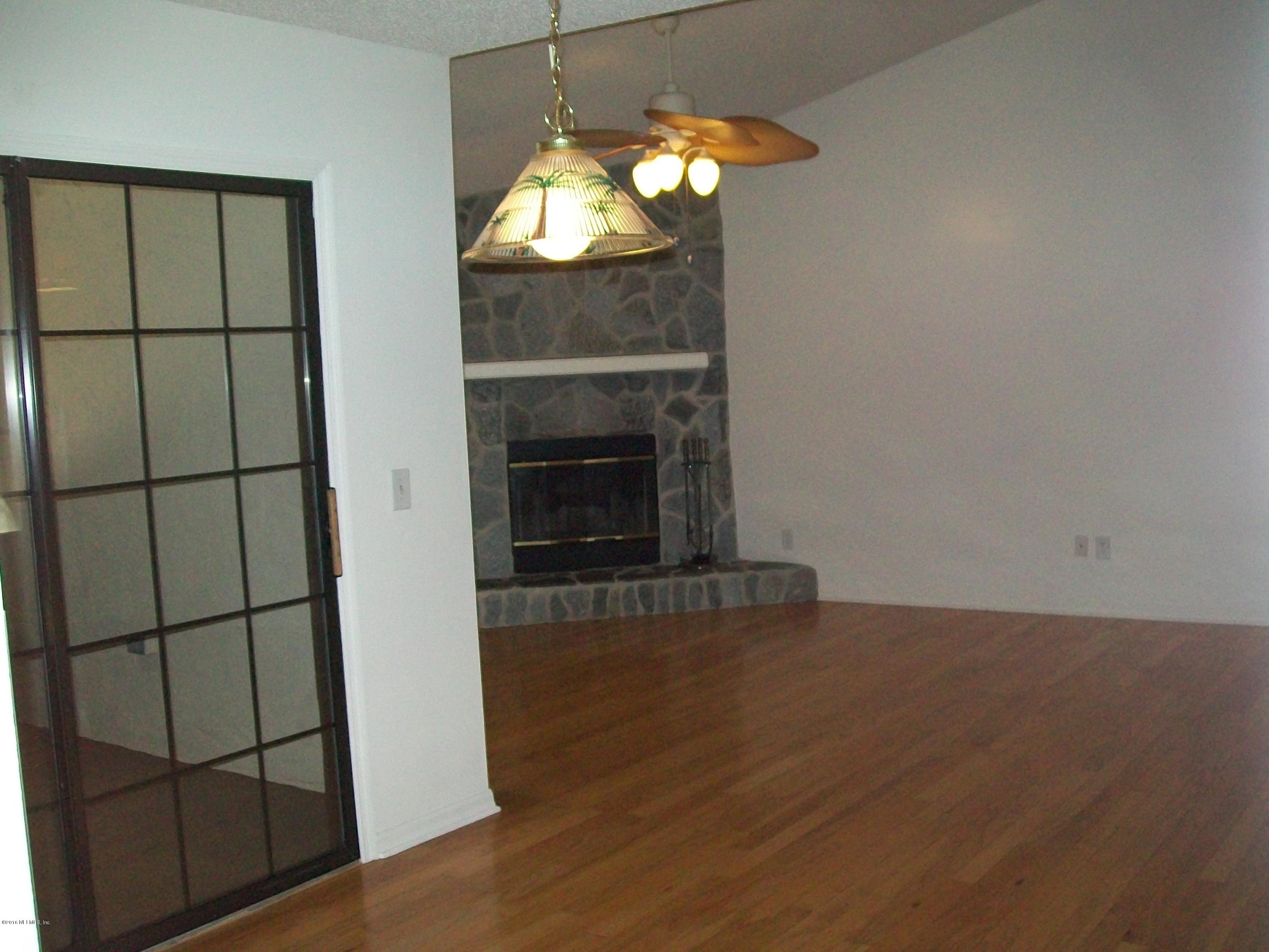 134 Dory Road St. Augustine, FL 32086 - Photo 11 of 25 an empty room with wooden floor fireplace and window