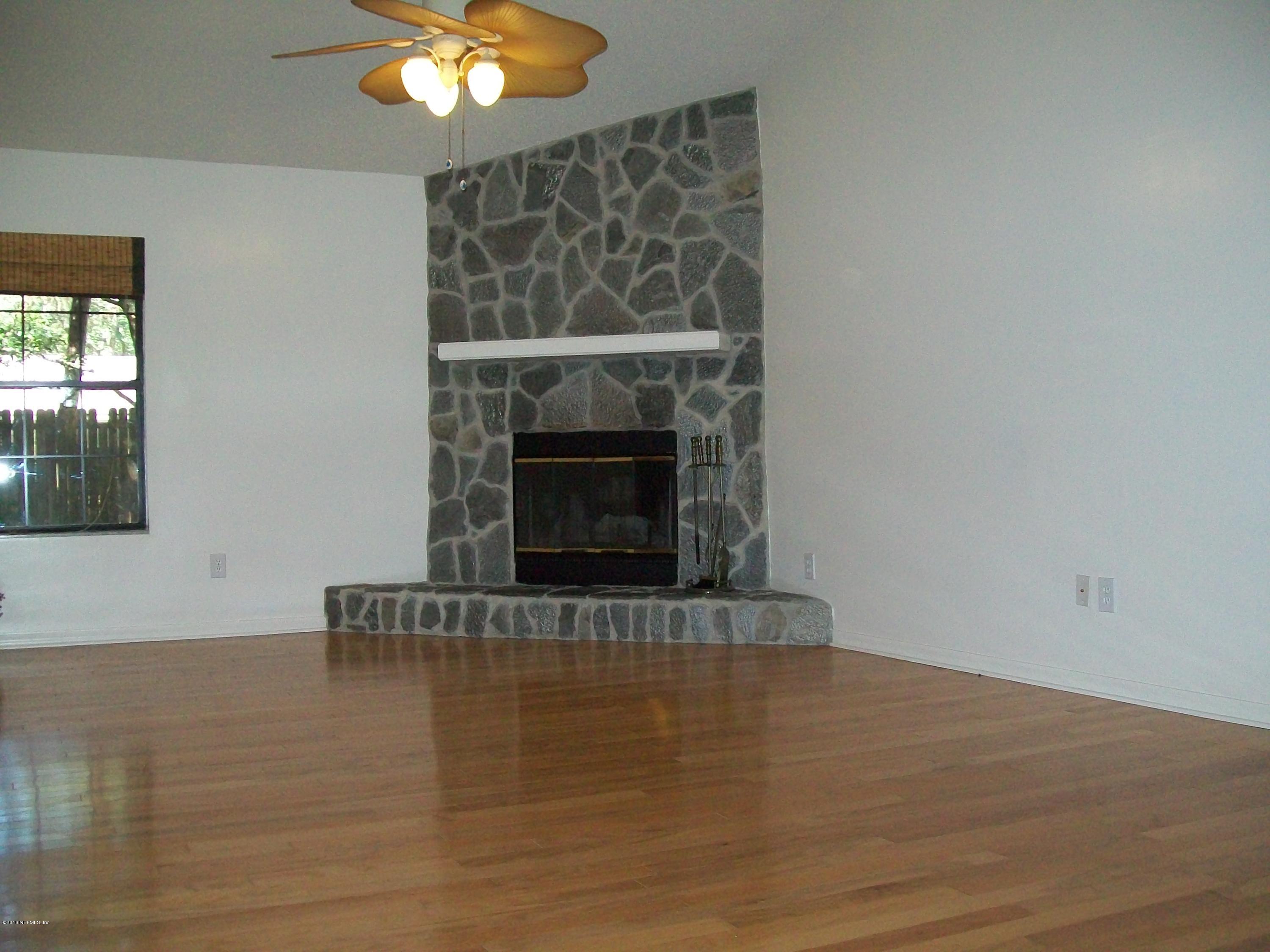 134 Dory Road St. Augustine, FL 32086 - Photo 7 of 25 a view of an empty room with wooden floor fireplace and a window