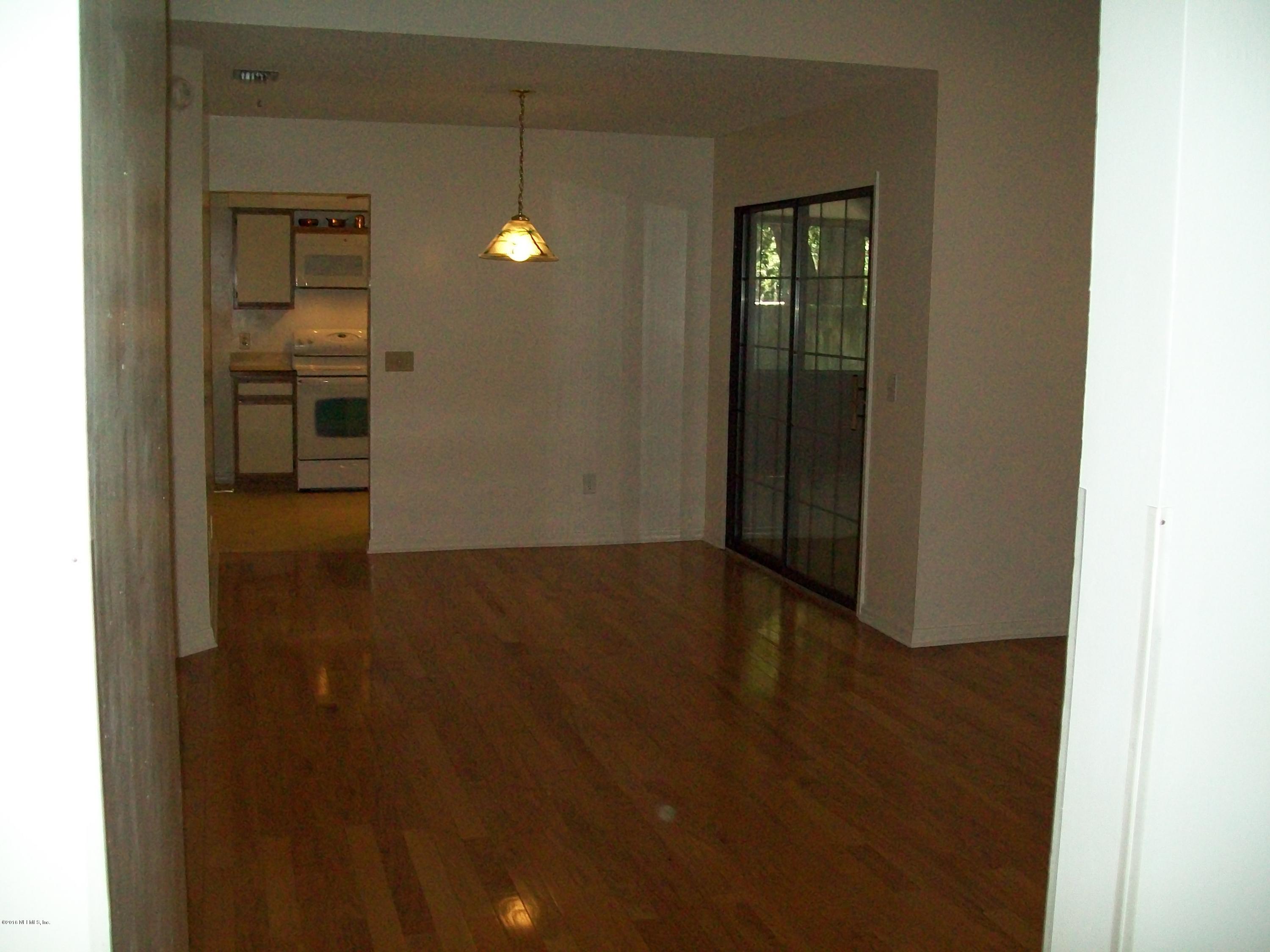 134 Dory Road St. Augustine, FL 32086 - Photo 9 of 25 a view of a hallway with wooden floor and a bathroom