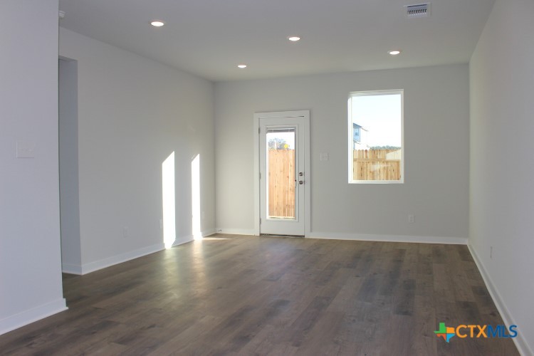 260 Escape Way Jarrell, TX 76537 - Photo 3 of 12 a view of an empty room with wooden floor and a window