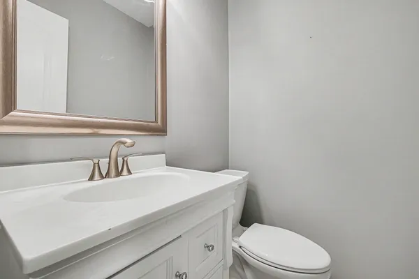 a bathroom with a sink a toilet and mirror