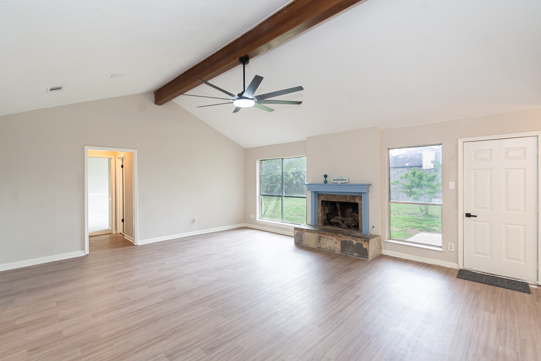 an empty room with floor fireplace and windows