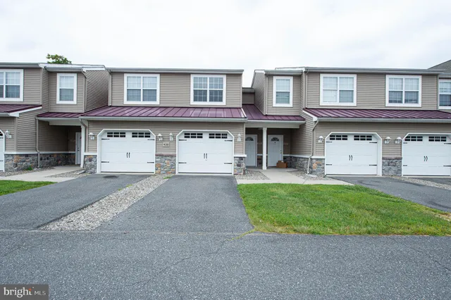 a front view of a house with a garden and parking