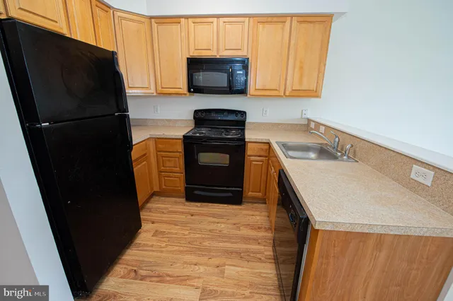a kitchen with a refrigerator stove and wooden cabinets