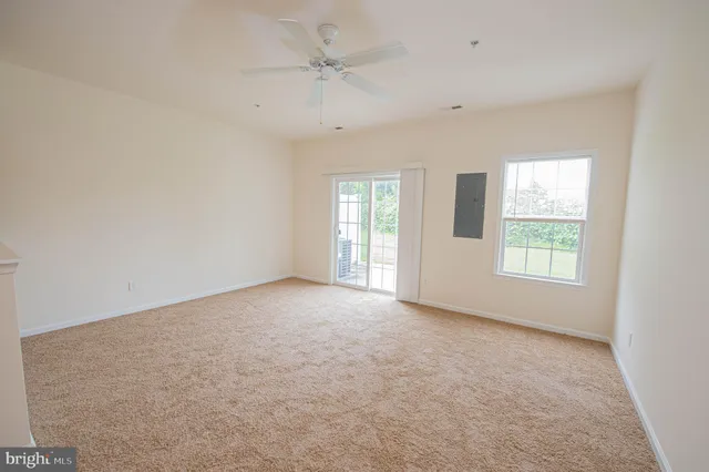 an empty room with a window and a ceiling fan