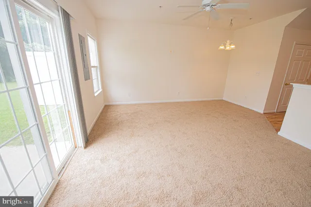 an empty room with a ceiling fan and a window