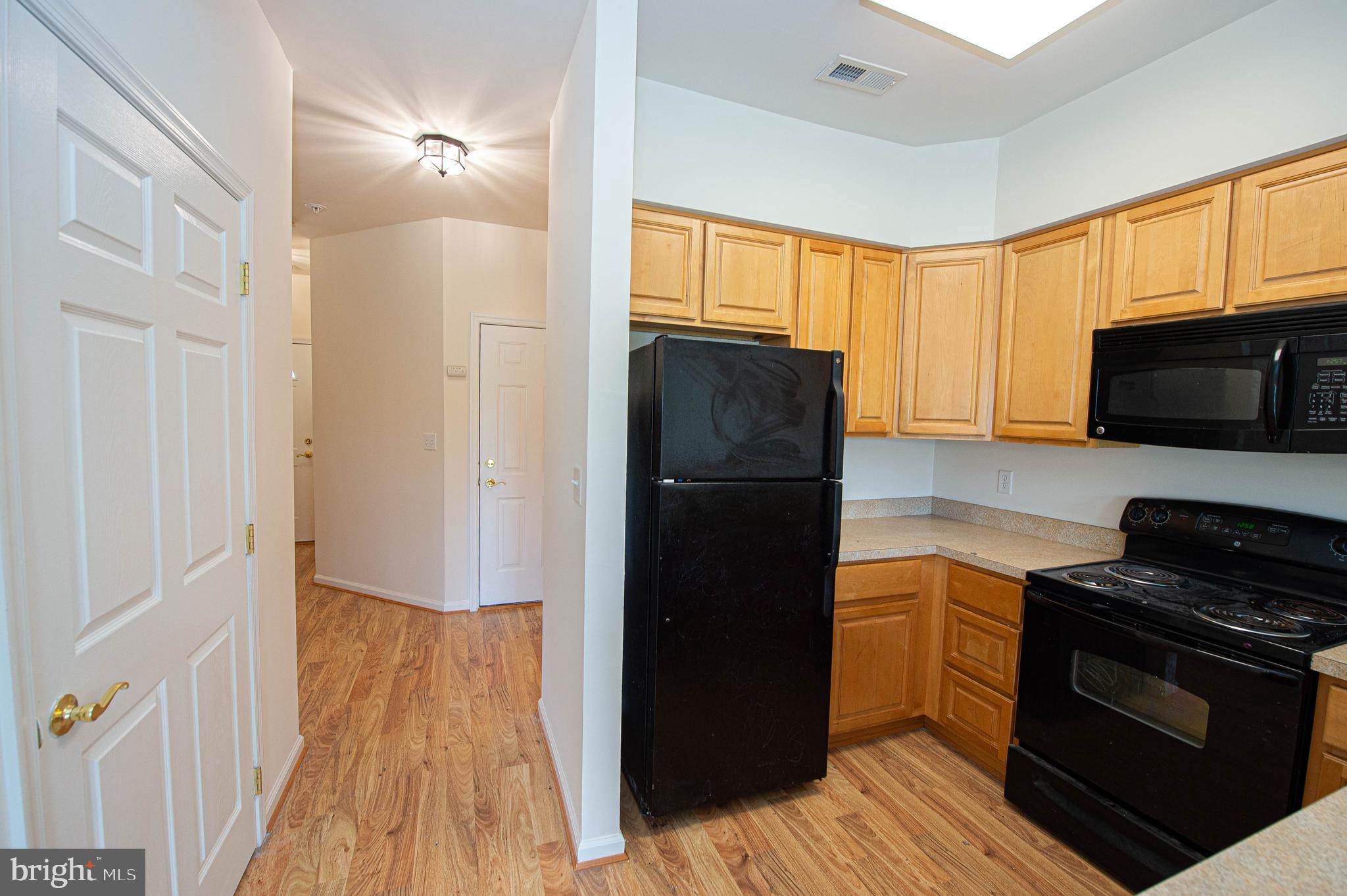 438 Parkview Court, Unit E Salisbury, MD 21804 - Photo 42 of 95 a kitchen with a refrigerator stove and wooden cabinets
