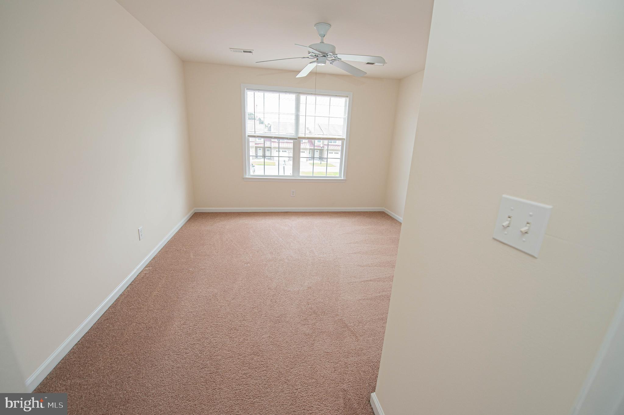 438 Parkview Court, Unit E Salisbury, MD 21804 - Photo 86 of 95 an empty room with windows and ceiling fan