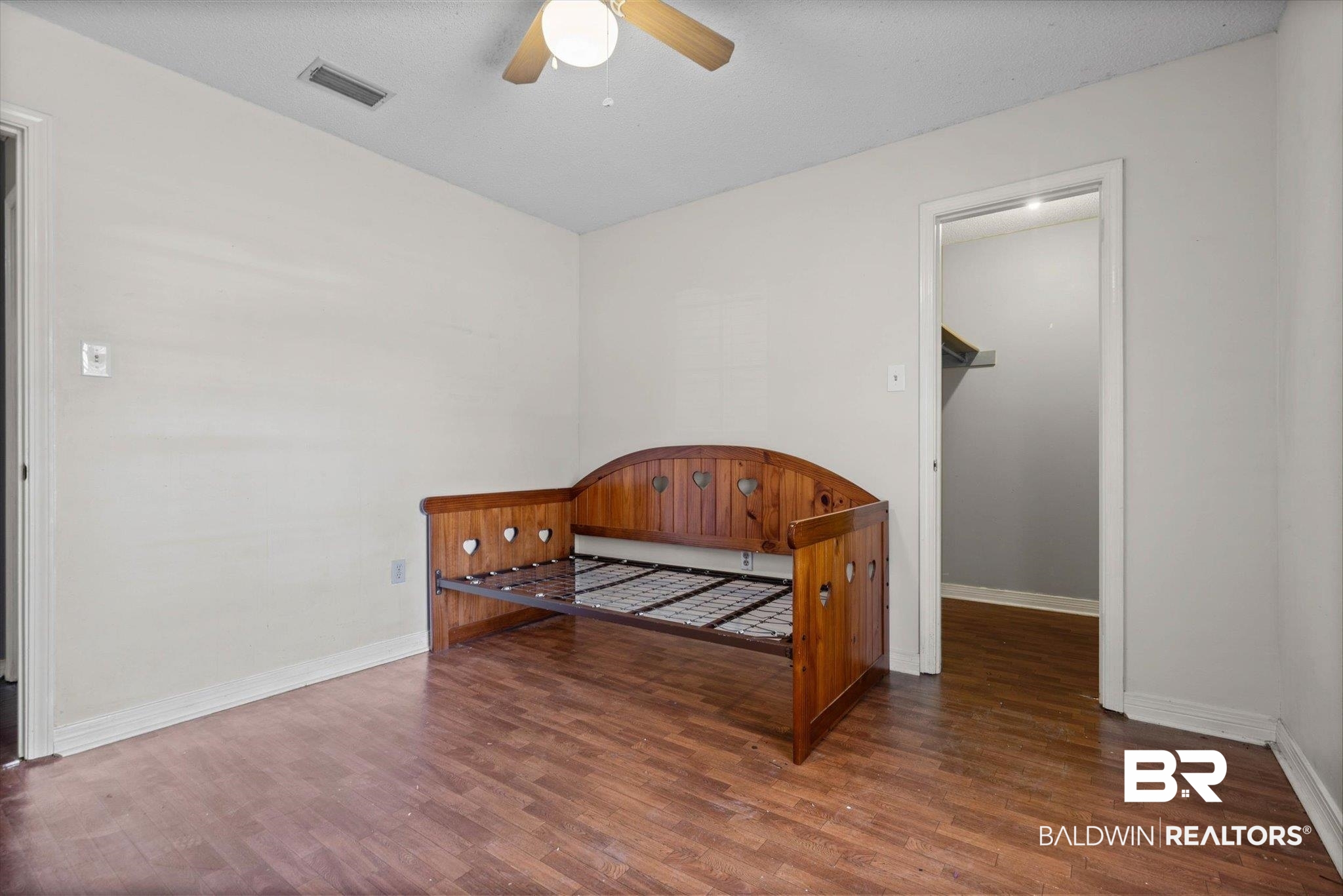 180 Creax Road Axis, AL 36505 - Photo 15 of 35 Bedroom featuring dark wood finished floors, ceiling fan, and a walk in closet